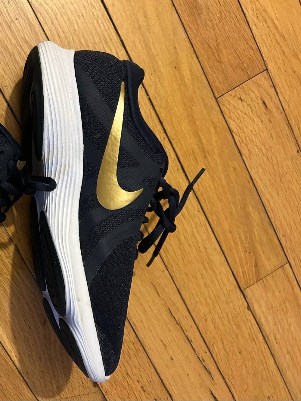Nike Women's Black Athletic Shoe with Gold Swoosh